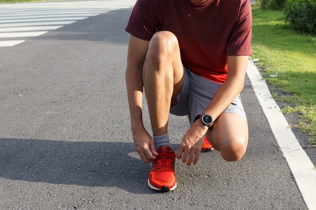 Close-up of sportsman.He tying sneakers on running shoes before practice. outdoor  Running concept.