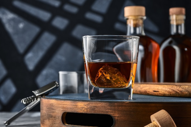 Close up of a square glass of whiskey with ice