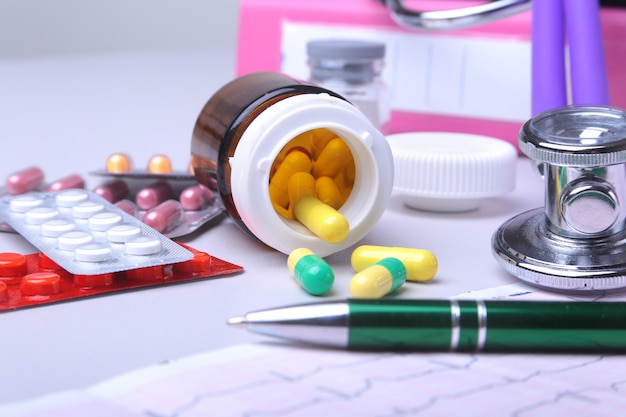 Close-up stethoscope lying on RX prescription with assorted pills. Healthy life or insurance .