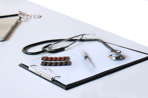 Close-up of stethoscope and paper on white background.