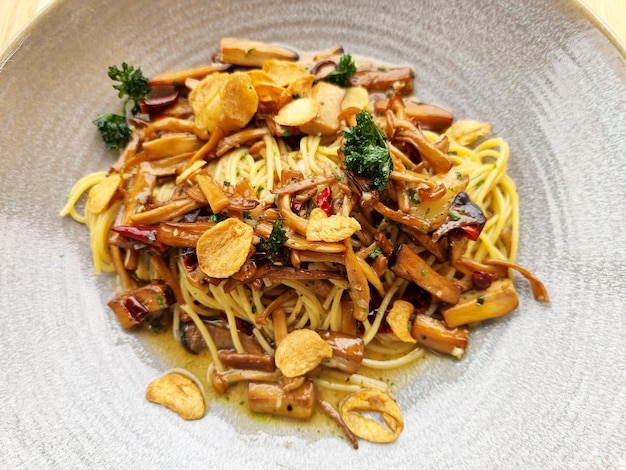 Close-up Stir fried spaghetti with dried chili and crispy bacon in a plate