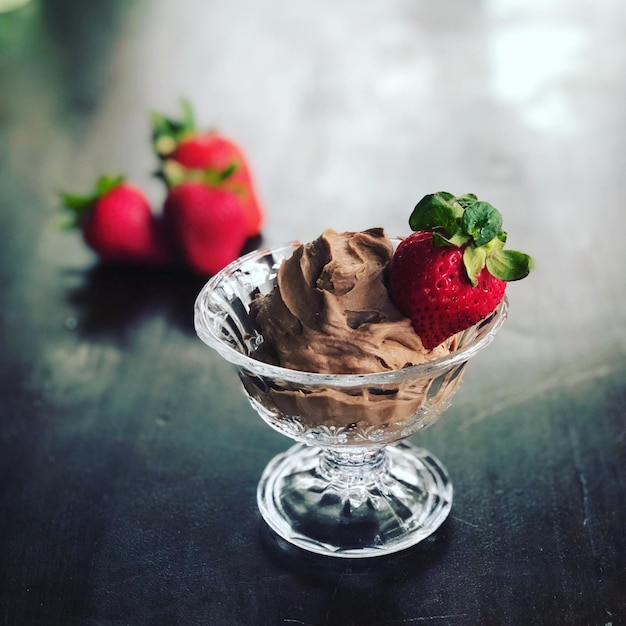 Photo close-up of strawberries  with chocolate on table