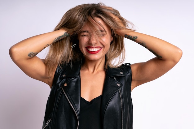 Close up studio positive portrait of pretty woman playing with her hairs happy mood stylish outfit