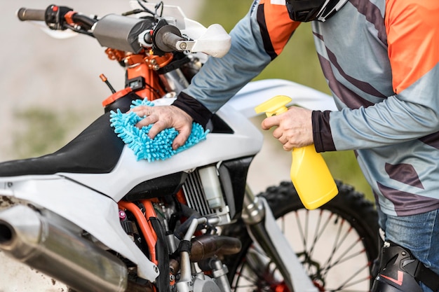 Close-up stylish man cleaning motorbike