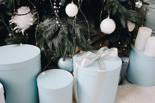 Close up of stylishly packed Christmas Gifts next to beautifully decorated Christmas Tree