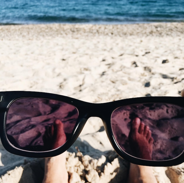 Photo close-up of sunglasses on beach