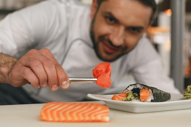 Close up of sushi master prepares sushi for serving in modern commercial kitchen