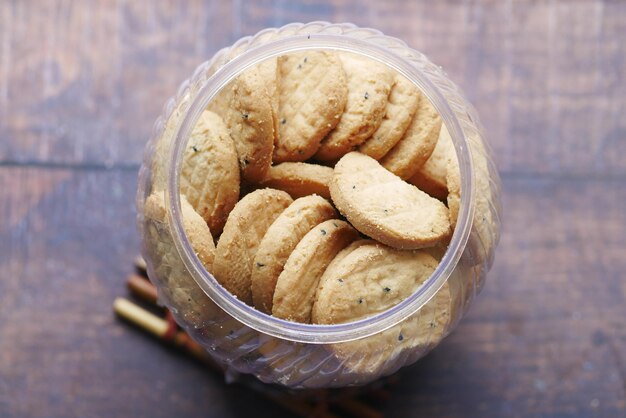 Close up of sweet cookies in a plastic jar on wooden table