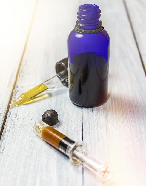 Close-up of syringe with medicine bottle on table