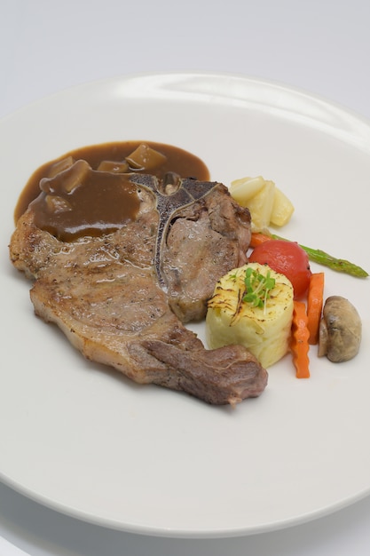 Close up T-bone steak on white plate and white background.