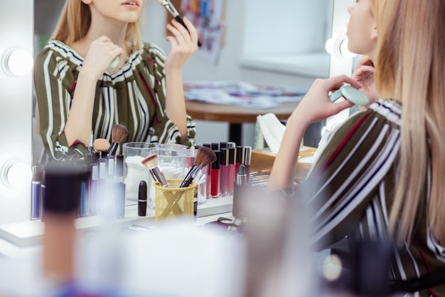 Close up of a table with lots of cosmetics lying on it