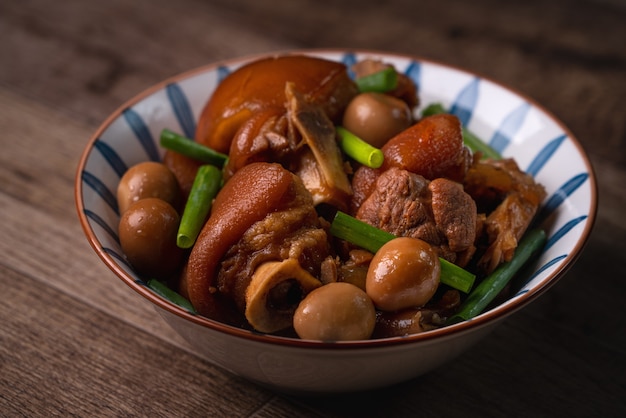 Close up of Taiwanese traditional food pork knuckle in a bowl on rustic table background.