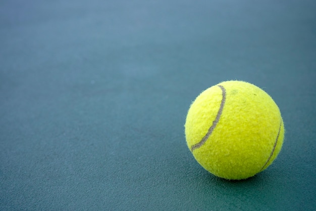 Close up tennis ball on the courts background.