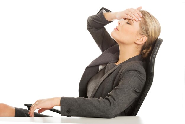 Photo close-up of tensed businesswoman sitting on chair against white background