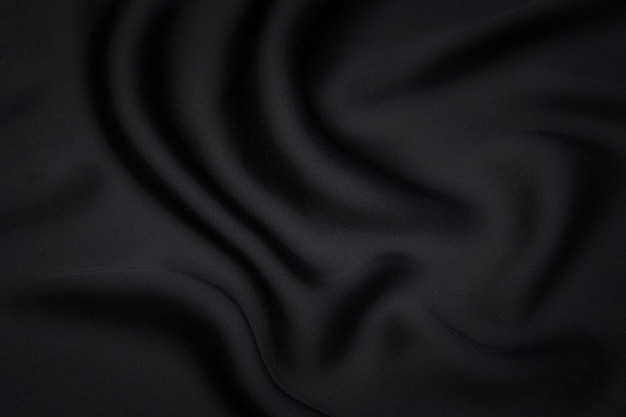 Close-up texture of natural gray or black fabric or cloth in same color. Fabric texture of natural cotton, silk or wool, or linen textile material. Black canvas background.