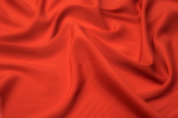 Close-up texture of natural red or pink fabric or cloth in same color. Fabric texture of natural cotton, silk or wool, or linen textile material. Red and pink canvas background.