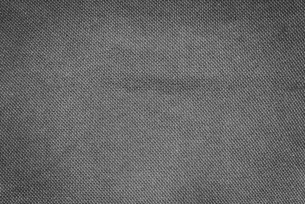 Close-up texture of natural weave cloth in dark and black color. Fabric texture of natural cotton or linen textile material. Black fabric wide background.