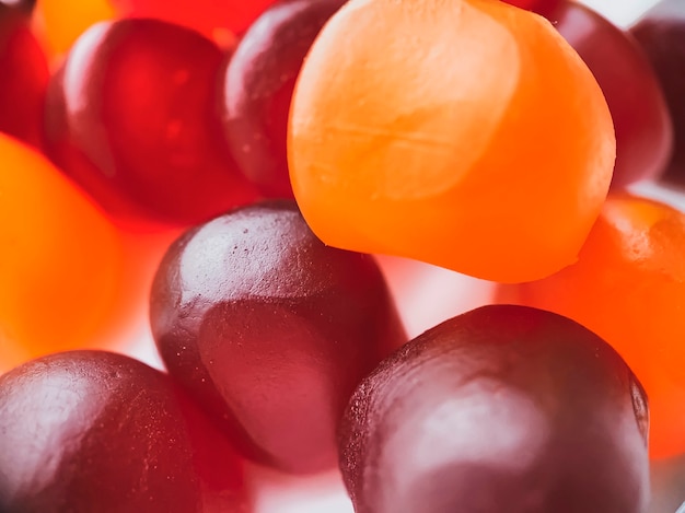 Close-up texture of red, orange and purple multivitamin gummies. Healthy lifestyle concept.