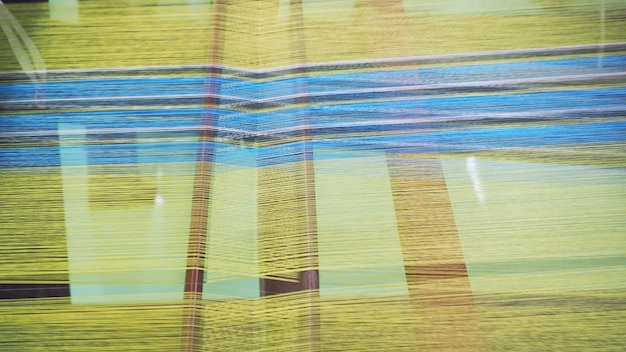 Close up of Thai Silk weaving on a traditional loom. Close up Thai silk thread. Making of thai silk.