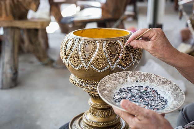 Close up Thai woman working on traditional wooden utensil