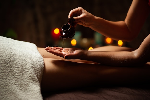 Close up of therapist pouring oil for a spa treatment