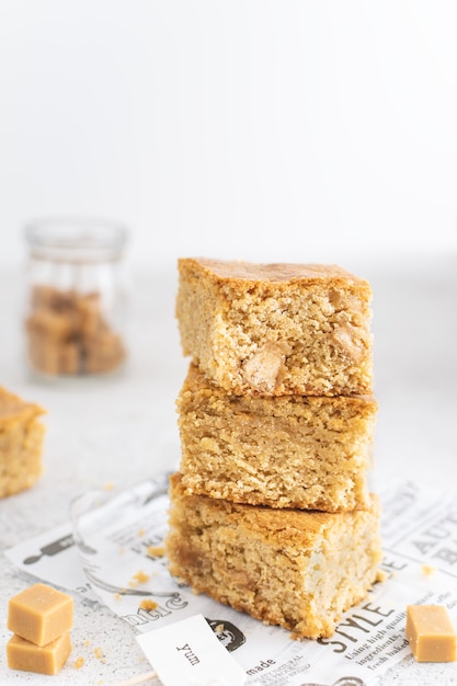 Close up of toffee caramel blondies, sweet pastry on light table