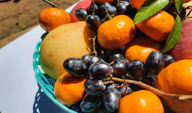 Close up, tropical fruits of oranges, grapes and pears in green basket on white background 02