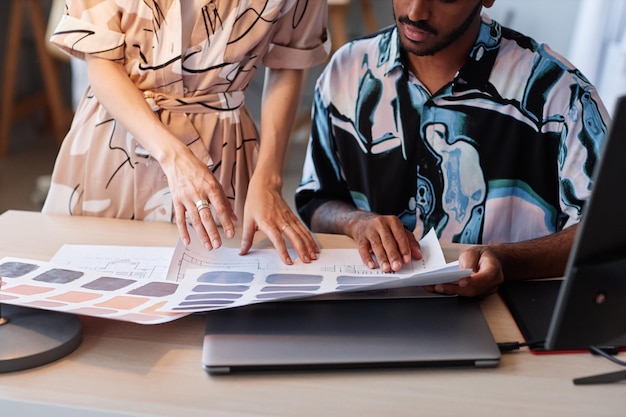 Close up of two creative designers choosing color palettes for interior design project copy space