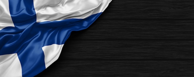 Close up of united states of Finland flag on the black wooden background 3d render