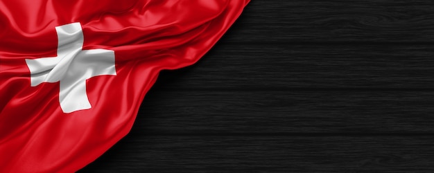 Close up of united states of Switzerland flag on the black wooden background 3d render