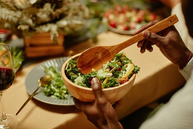 Close up of unrecognizable africanamerican man serving food while enjoying dinner with family