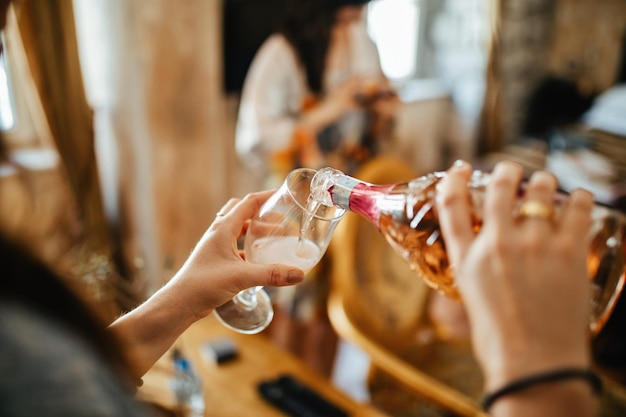 Close up of unrecognizable woman filling glass with Champagne