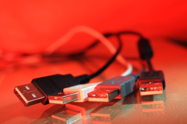 A close up of a usb cable with a red background