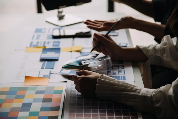 Close up ux developer and ui designer use augmented reality brainstorming about mobile app interface wireframe design on desk at modern officeCreative digital development agency