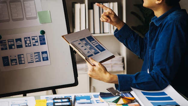 Close up ux developer and ui designer use augmented reality brainstorming about mobile app interface wireframe design on desk at modern officeCreative digital development agency