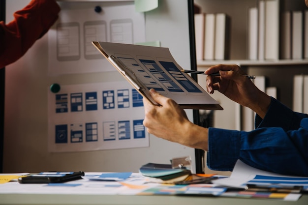 Close up ux developer and ui designer use augmented reality brainstorming about mobile app interface wireframe design on desk at modern officeCreative digital development agency