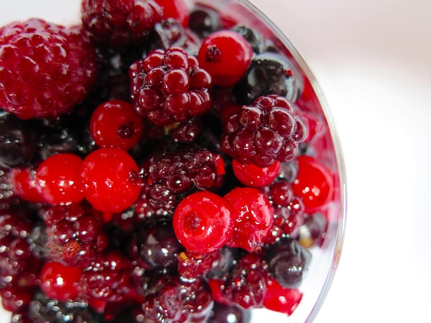 Close-up of various berries in bowl on white background