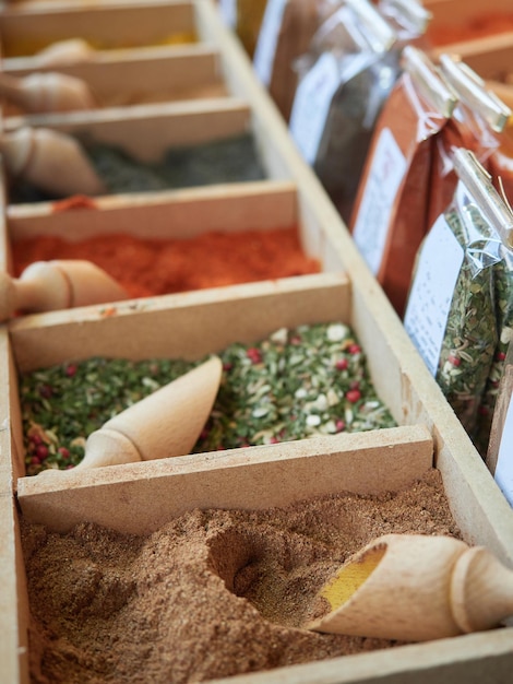 Close-up of various spices and culinary seasonings for sale. Bulk packed in wooden crates and packaged in sachets.