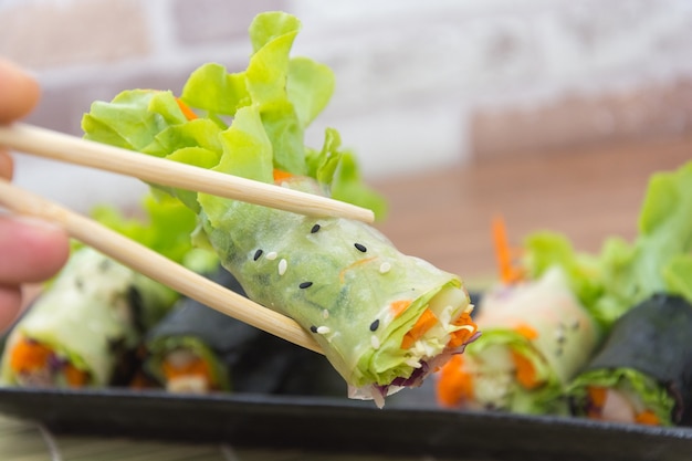 close up of vegetable salad roll and sauce