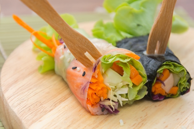 close up of vegetable salad roll and sauce