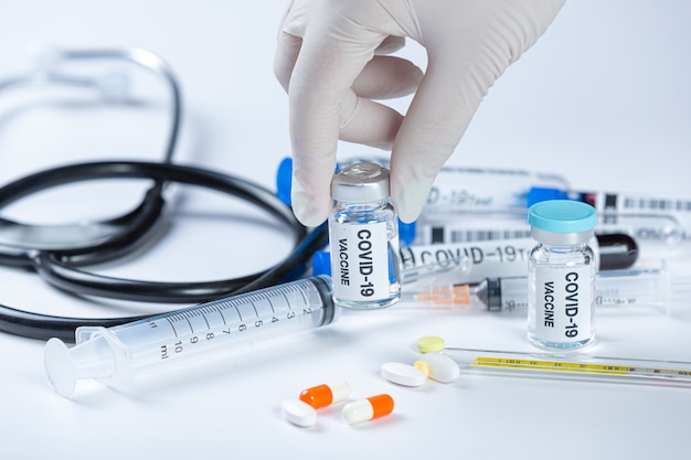 Close up a vial of covid-19 vaccine in hand of a scientist or doctor