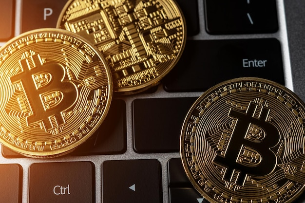 Close up view of Bitcoin gold coins on laptop keyboard