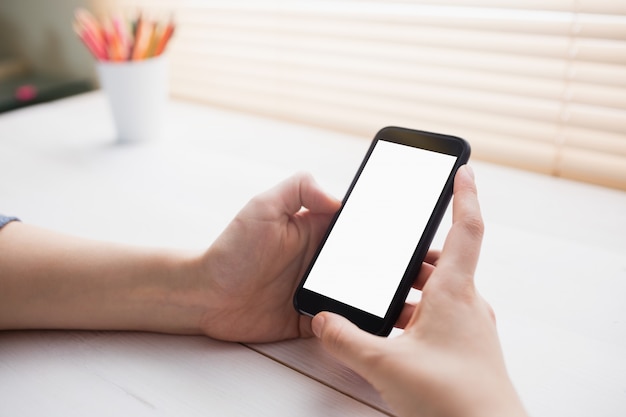 Close up view of businesswoman using her phone at her desk in office