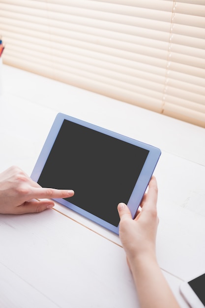 Close up view of businesswoman using her tablet at her desk in office