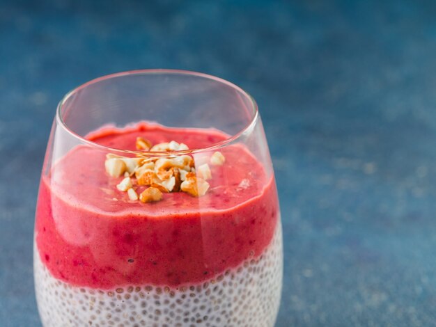 Close up view of Chia pudding with red berry puree and chopped almonds.