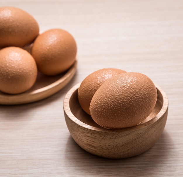 Close-up view of chicken eggs on wooden table background