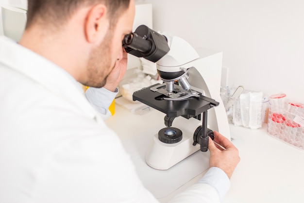 Close up view at the doctor looks through the microscope