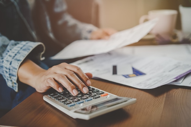 Close up view hands of person calculating monthly expense.