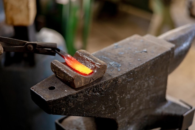 Photo close up view of heated metal and anvil the blacksmith in the production process of metal products