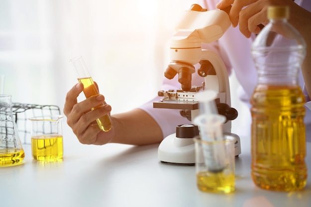 Close up view of industrial worker with vegetable oil quality test in the room